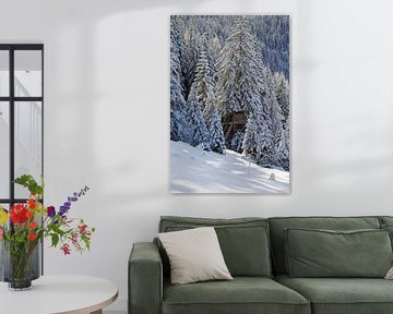 Un beau paysage d'hiver romantique avec une forêt d'épicéas fraîchement enneigée et la vue d'un sièg sur chamois huntress