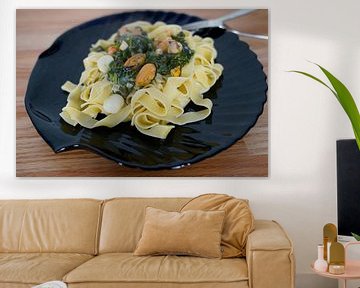 Fettuccini met spinazie en kaas roomsaus en zeevruchten geserveerd op een bord
