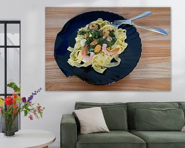 Fettuccini met spinazie en kaas roomsaus en zeevruchten geserveerd op een bord