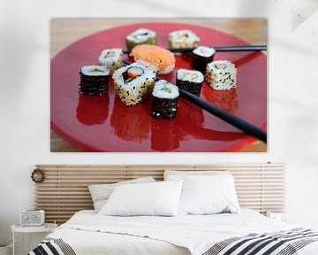 Sushi op een rood bord met eetstokjes