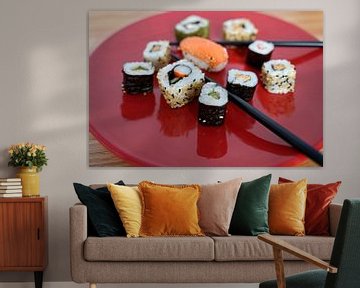 Sushi angeordnet auf einem roten Teller mit Stäbchen