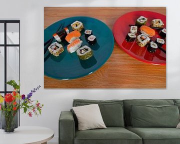 Sushi auf einem Teller mit Stäbchen angeordnet