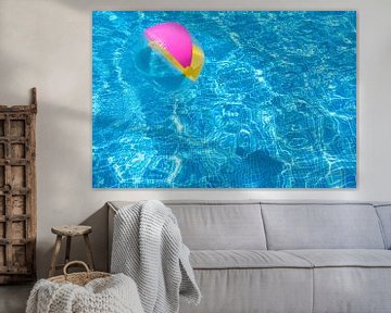 Swimming pool water surface with floating inflatabel beach ball by Alex Winter