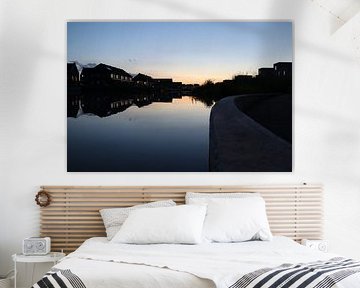 Huizen aan het water in de ondergaande zon