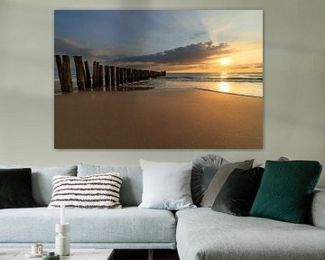 zonsondergang boven strand met rij palen van FotoBob