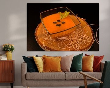 Soupe maison carotte-gingembre avec graines de courge dans un bol en verre