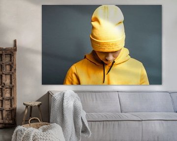 stylischer Teenager mit gelbem Hoodie senkt den Kopf von Besa Art