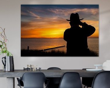 Een fotograaf bij een prachtige zonsondergang aan zee van Denny Gruner