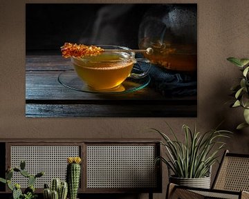 Hot steaming tea a glass cup with a stick of rock candy on a dark rustic wooden table, copy space, s by Maren Winter