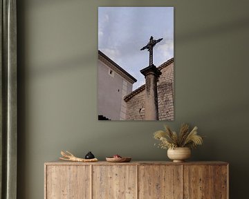 Fotoabzug eines Kreuzes auf einer Statue in der belebten französischen Stadt Ruoms in der sonnigen R von Fotograaf Elise