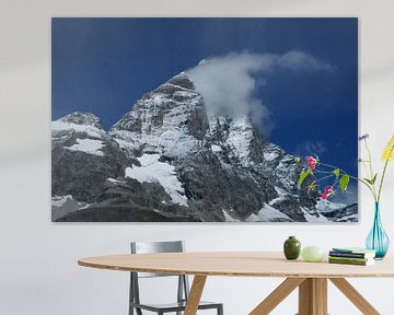 De Matterhorn gaat schuil achter een wolkje met stralend blauwe lucht. van Gert van Santen