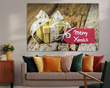 Kerstmisgeschenk met groet etiket Merry Xmas op houten achtergrond van Alex Winter