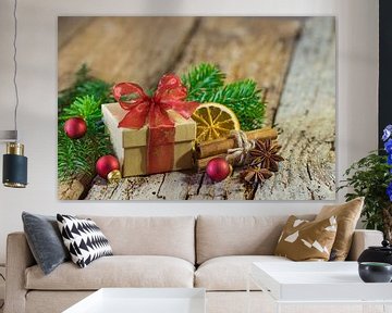Kerstcadeau met rood lint en natuurlijke versieringen op houten achtergrond van Alex Winter