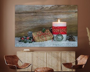 Brandende kaars met kerstgeschenk, dennentak en dennenappels natuurlijke decoratie van Alex Winter