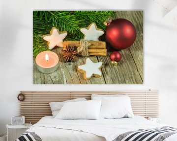Kerstcompositie van sterrenkoekjes, specerijen, kaarslicht, rode ballen en sparrentakken van Alex Winter