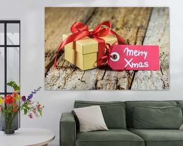 Cadeau de Noël avec étiquette de vœux Joyeux Noël sur fond de bois sur Alex Winter