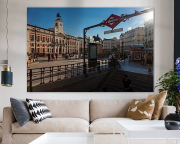 Puerta del sol, the heart of Madrid with a view on the typical metro sign, the city hall and sunbeam by Kim Willems