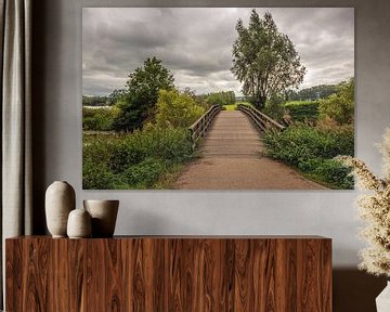 Eenvoudige houten brug over een smalle Nederlandse rivier van Ruud Morijn