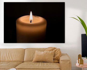 Brennende Kerze vor schwarzem Hintergrund