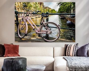 Bicycle on bridge railing over canal in Amsterdam Netherlands by Dieter Walther