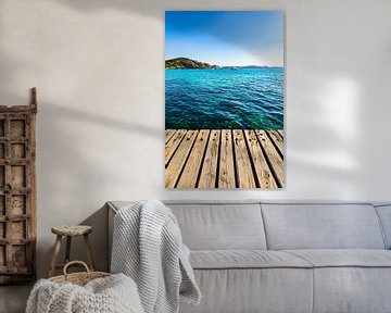 Houten pier met blauw zeewater en kustlandschap achtergrond van Alex Winter