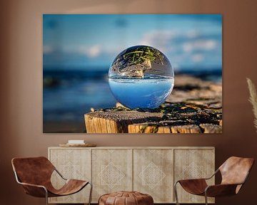 Glass sphere on a groyne at the Baltic Sea. The groyne is reflected in the sphere. by Martin Köbsch