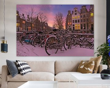 Stadsgezicht van besneeuwd Amsterdam bij zonsondergang in Nederland van Eye on You