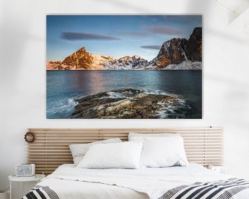 Ice sheets on dark rock with lake and snow-clad steep mountains in the Reinefjord on the Lofoten isl by Robert Ruidl