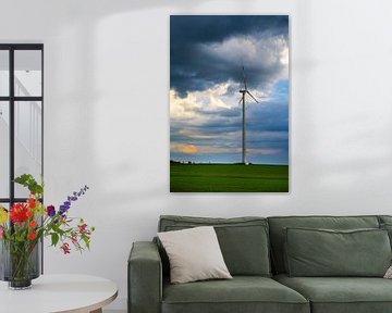 Dramatic sky over wind turbine on green field by adventure-photos