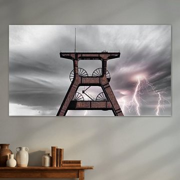 Ein alter stillgelegter Förderturm vor beeindruckenden Blitzen am Himmel