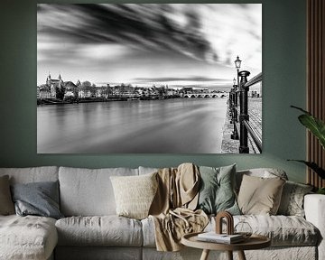 Maastricht and the Servaas bridge in black and white with moving clouds and soft water in the Maas by Kim Willems