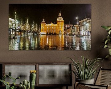 Das schön beleuchtete Rathaus von Goes spiegelt sich in den nassen Klinkern des Platzes von Gert van Santen