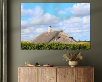 Thatched roof in front of blue sky with white clouds by Ines Porada