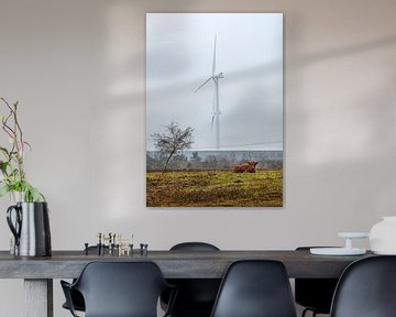 Scottish highlander sitting in nature with wind turbine in background by Chihong