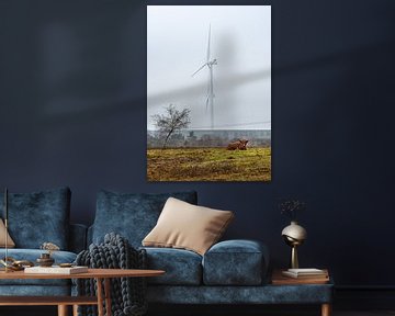 Schotse hooglander zittend in de natuur met windturbine op de achtergrond van Chihong