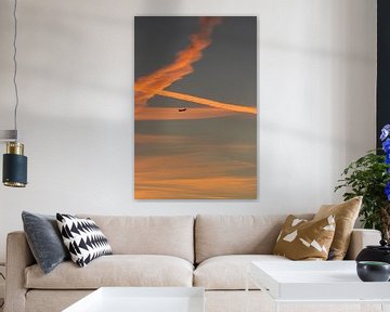 Zonsondergang met een bewolkte lucht en een vliegtuig van Maarten Borsje