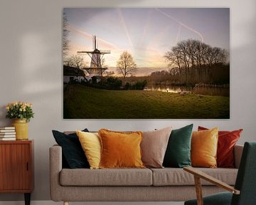 Winters landschap met molen en zonsondergang in Nederland