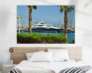 Große blau-weiße Yacht liegt zwischen zwei grünen Palmen im Hafen von Alicante unter sonnigem blauem von LuCreator
