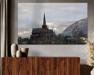 Église en bois de Lom en Norvège avec des montagnes enneigées en arrière-plan.