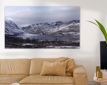 First snow on the mountains at a frozen mountain lake on the Valdresflye panorama route in Norway