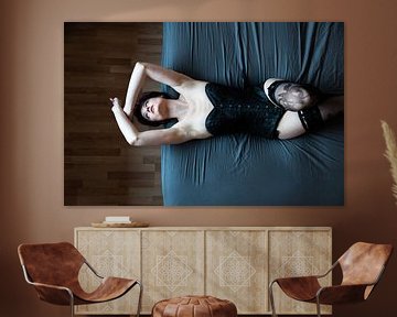 Blick von oben auf eine 23-jährige Frau, die auf einem blauen Bett liegt von Werner Lerooy