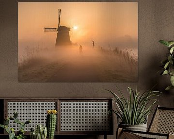 Radfahren durch den Nebel in der Nähe einer Mühle an einem sonnigen Morgen von Jeroen de Jongh