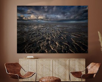 Dreigende wolkenluchten boven de waddenzee. Bij laag water blijv