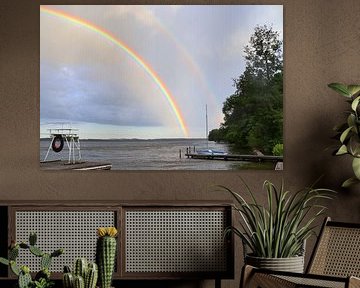 A double rainbow over a lake before a thunderstorm