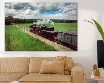 Steam train with smoke from the locomotive driving through fields by Sjoerd van der Wal Photography