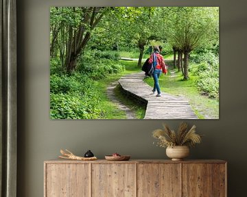 Active thrity year old woman walking a wooden trail through the  van Werner Lerooy